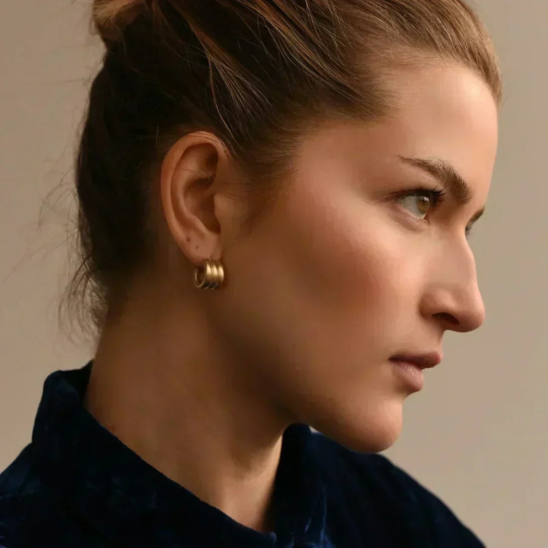 Woman in profile wearing sculptural gold hoop earrings, by 8.6.4