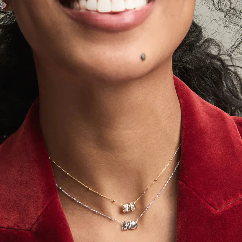 Woman smiling while wearing LADDER’s Saturn chain necklace, designed by Adina Reyter.