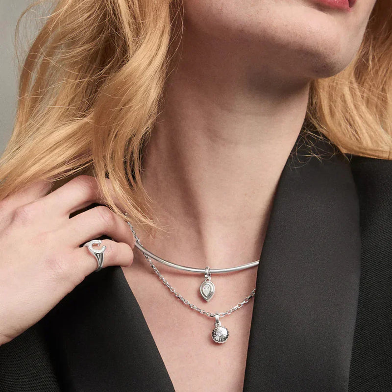 Woman wearing Adina Reyter’s silver charm necklace, available at LADDER.