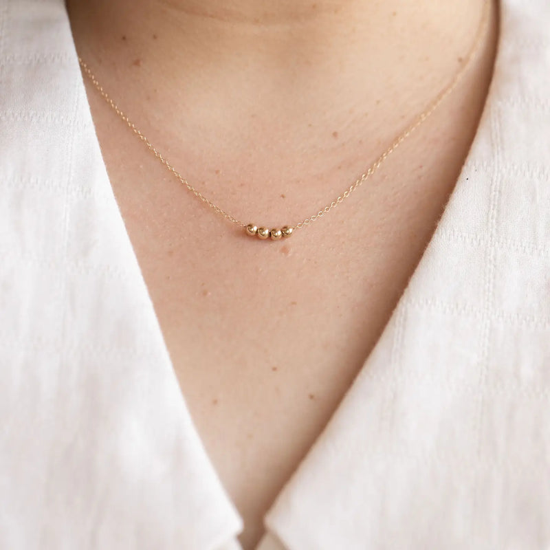Gold sphere necklace from LADDER, designed by Sheena Marshall Jewelry.