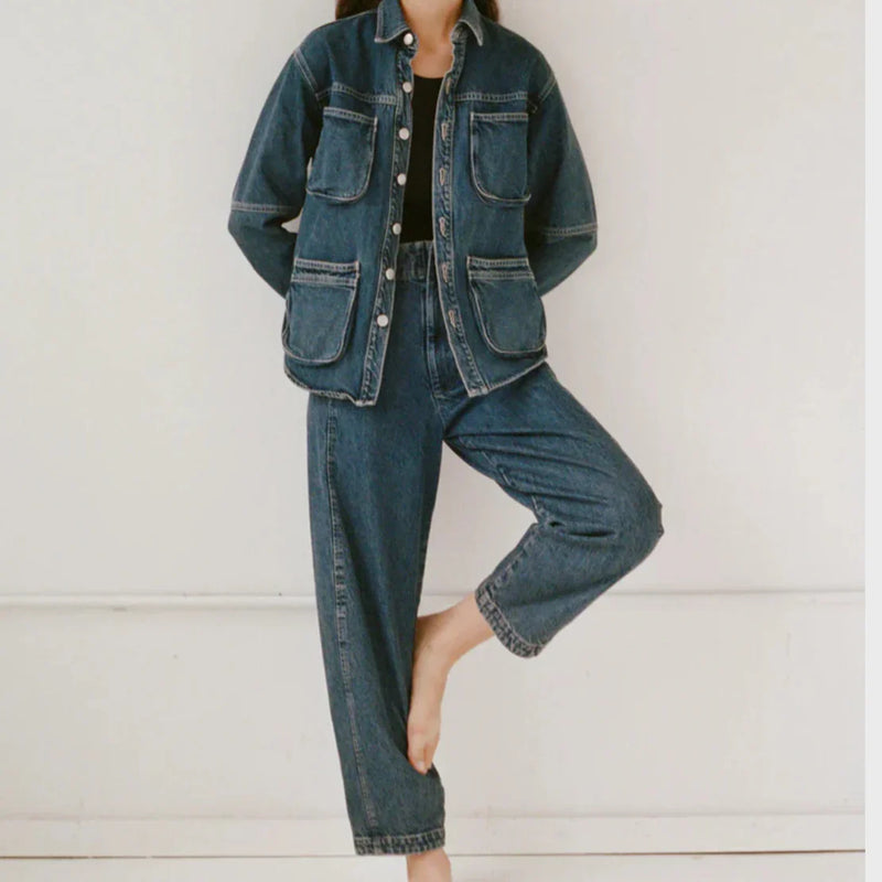 Woman wearing a denim jacket over a black top with relaxed blue jeans, styled for an everyday LADDER look.